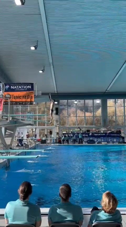 Plongeur en vol après son appel depuis la plateforme, au-dessus du bassin de la piscine de Vaise à Lyon